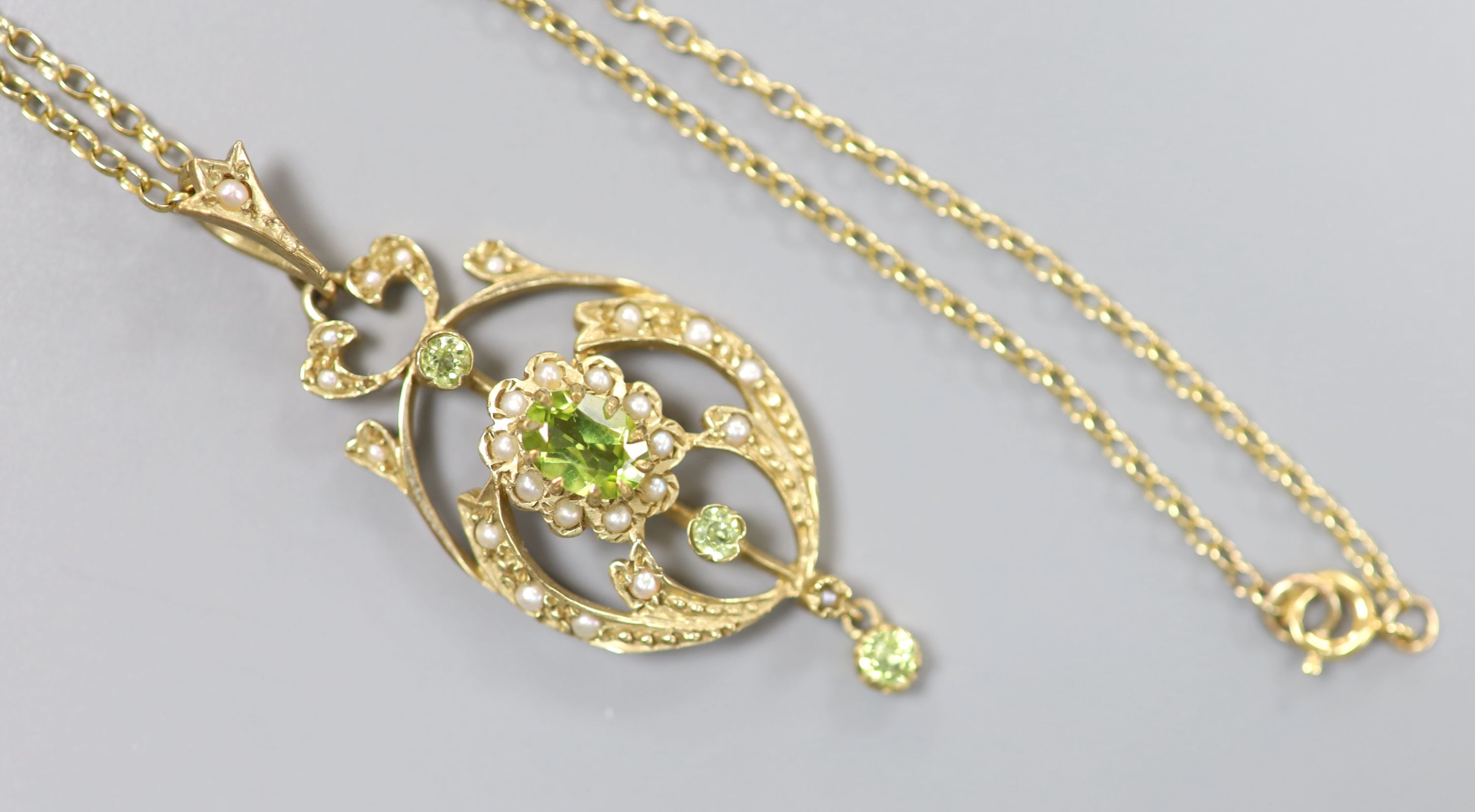 A modern 9ct gold, peridot and seed pearl set drop pendant, 47mm, on a 9ct chain, 46cm